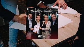 Bild mit 4 Personen, einer Frau und drei Männerg, welche in die Kamera lächeln