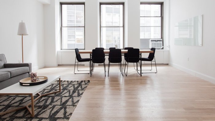 Bild von Esszimmer, mit Tisch und Stühlen, welche auf einem Holzboden stehen