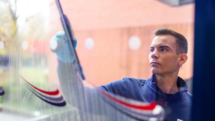 Mann beim Fenster Putzen